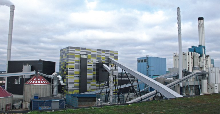 View of boiler house with biomass in-feed from the left and waste from centre.