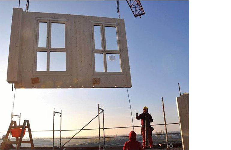 A crane moving a fascade element into place (photo courtesy RWTplus).