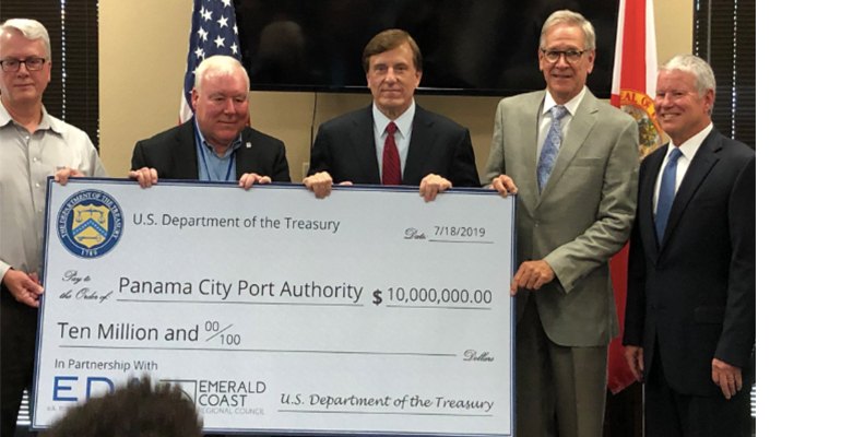 Assistant Secretary Dr John Fleming (centre) presents Panama City Port Authority leaders with a US$10 million check. This EDA investment will help build a new biomass bulk storage facility to increase the bulk cargo exporting capabilities and protect the port against extreme weather (photo courtesy US EDA).